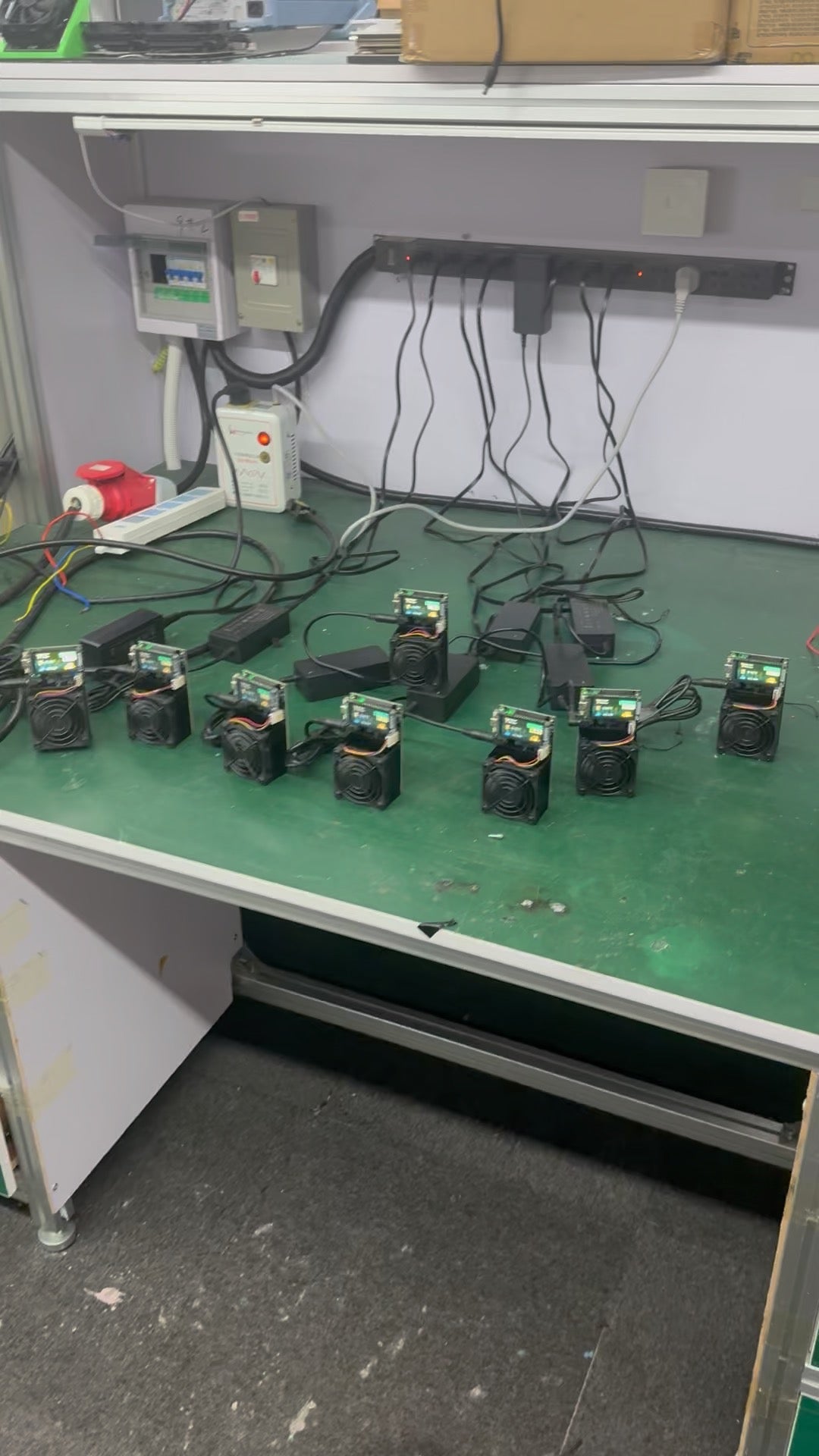 A full bench of units under test — every board runs before a single one ships.
