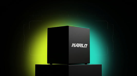 The Harlo H15 Dual on a black plinth in a dark studio, its HARLO labs side panel lit by a lime and teal glow behind it