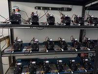 NerdQaxe++ rack — three shelves of units running on Meanwell LRS-series PSUs at Helium Deploy