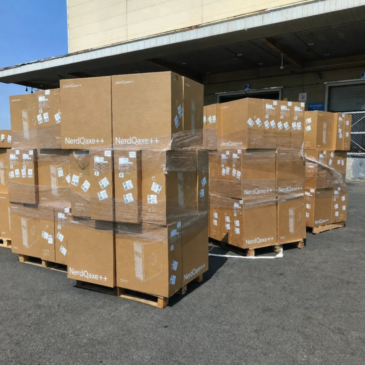 Pallets of NerdQaxe++ stacked at the manufacturer's loading dock in Shenzhen — bought direct, no resellers.